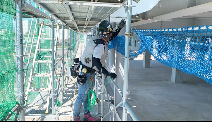 作業に取り組んでいる社員がいる建設現場の足場の上